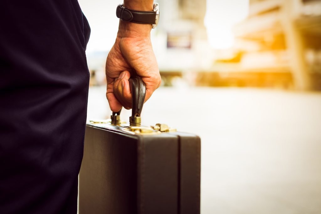 A loan signing agent in business suit bring a brief case ready for his notary signing career.